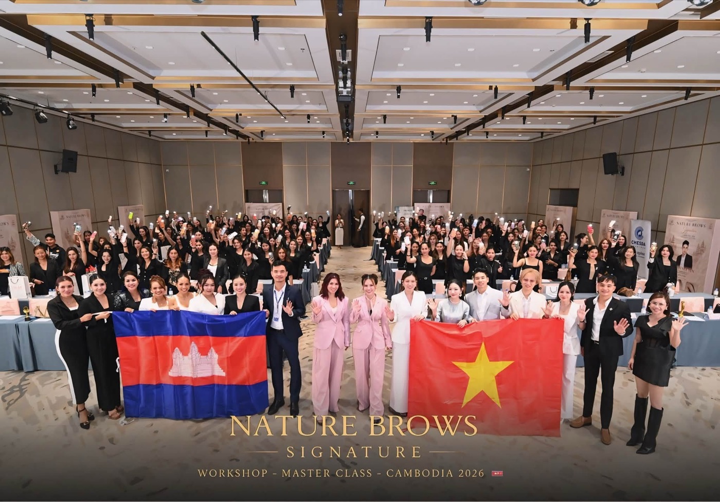 Tập thể Nature Brows Signature Cambodia 2026 với cờ Việt Nam và Campuchia